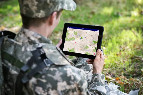 Soldado usando mapa no tablet para orientação na floresta — Fotografia de Stock