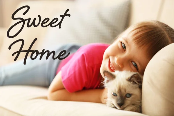 고양이 소파에 누워 작은 귀여운 소녀. 텍스트 스위트 홈. — 스톡 사진