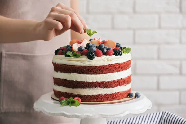 Mulher decoração bolo delicioso — Fotografia de Stock