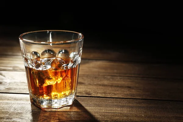 Glass of whisky on wooden table — Stock Photo, Image