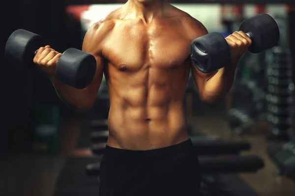 Athletic man training with dumbbells — Stock Photo, Image