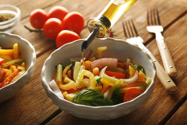 Despejar azeite em salada de legumes — Fotografia de Stock