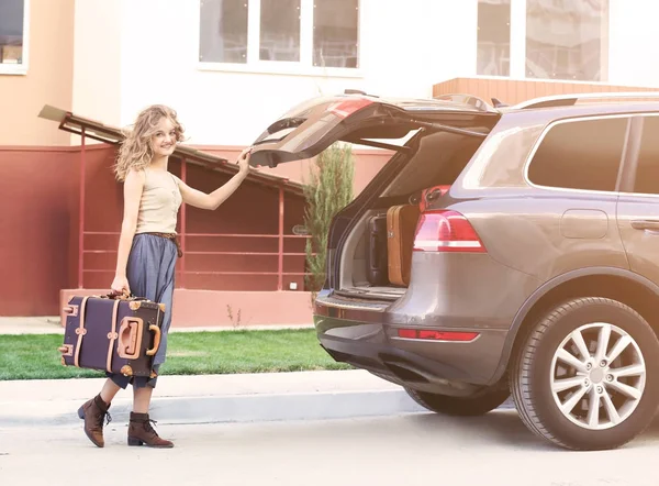 Jeune femme avec valise près du coffre de la voiture — Photo