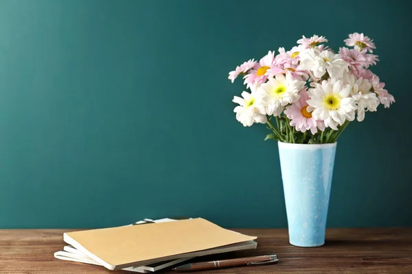 Copybooks and flowers on teacher 's desk — стоковое фото