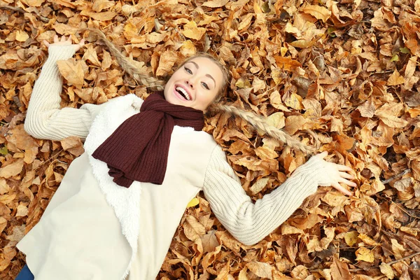Krásná dívka leží na listy na podzim park — Stock fotografie