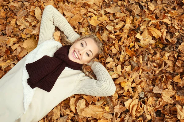 Krásná dívka leží na listy na podzim park — Stock fotografie