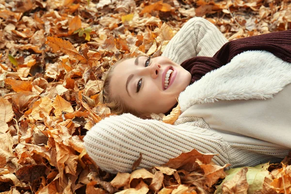 Krásná dívka leží na listy na podzim park — Stock fotografie