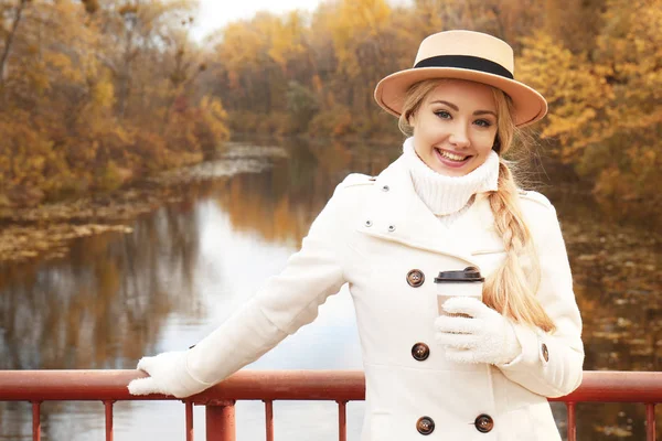 Beautiful girl with coffee in autumn park — Stock Photo, Image