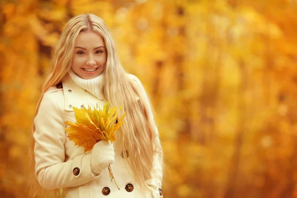 Schönes Mädchen mit Blätterstrauß im Herbstpark — Stockfoto