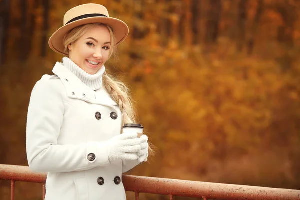 Красивая девушка с кофе в осеннем парке — стоковое фото