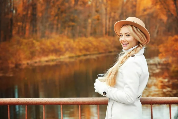 Menina bonita com café no parque de outono — Fotografia de Stock