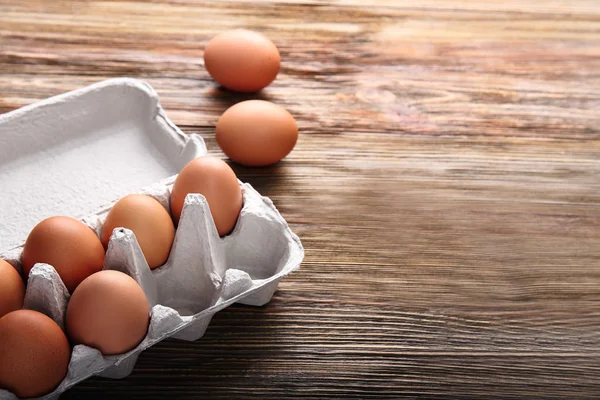 Eggs package on wooden table — Stock Photo, Image