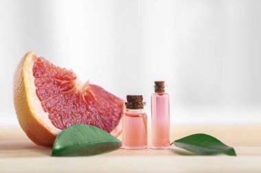 Greyfurt dilim, esans ve ahşap masa yapraklarda ile şişe