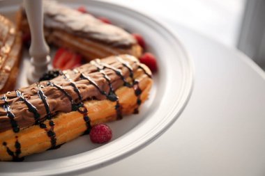 Lezzetli renkli eklerleri meyveler ve meyve plaka, yakın çekim