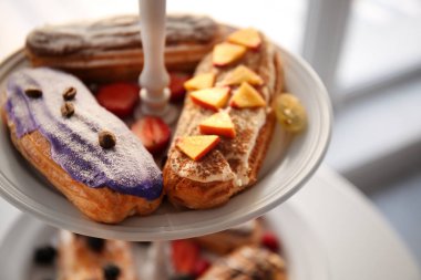 Tatlı çilek ile lezzetli renkli eklerleri standı, portre