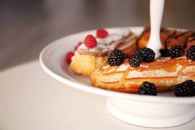 Lezzetli renkli eklerleri meyveler ve meyve plaka, yakın çekim