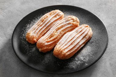 Siyah plaka üzerinde pudra şekeri ile lezzetli eklerleri