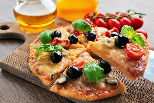 Affettato gustosa pizza e pomodorini freschi su tagliere di legno — Foto Stock