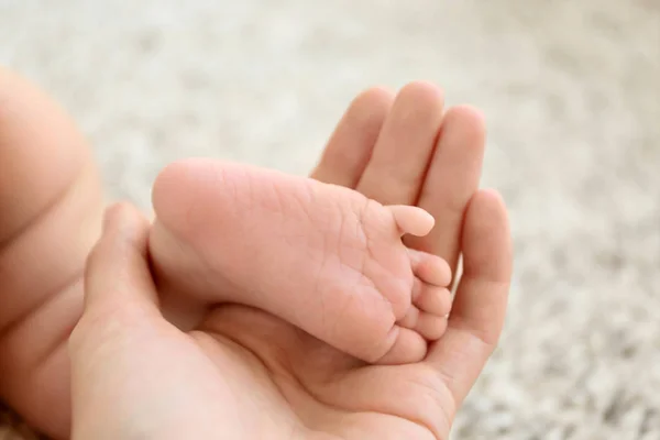 Woman holding cute small baby foot, closeup — Stock Photo, Image