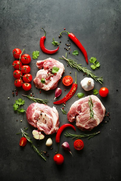 Surowe mięso, pomidory i przyprawy na szarym tle — Zdjęcie stockowe
