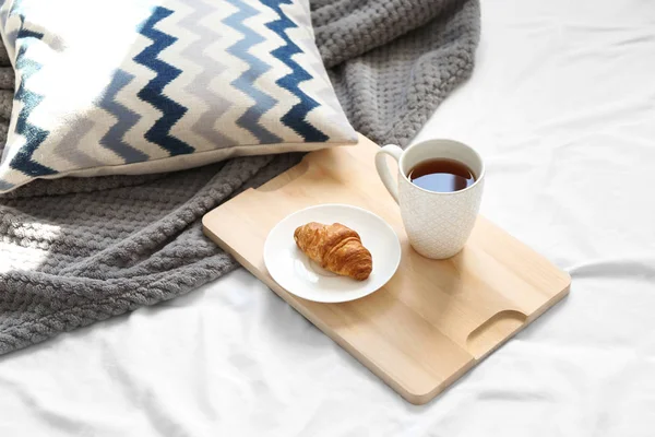 Taza de té y croissant en bandeja de madera. Desayuno en la cama — Foto de Stock