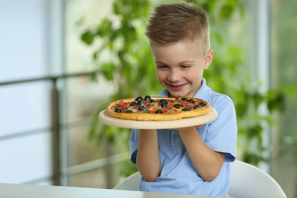 Cute boy with hot pizza at home — Stock Photo, Image