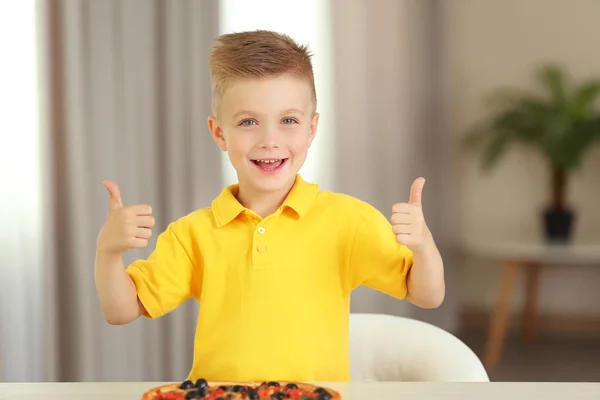 Schattige jongen met hete pizza thuis — Stockfoto