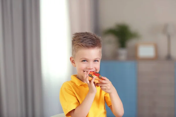 Ładny chłopak w domu jedzenie pizza — Zdjęcie stockowe