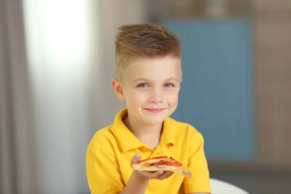 Cute boy eating pizza at home — Stock Photo, Image