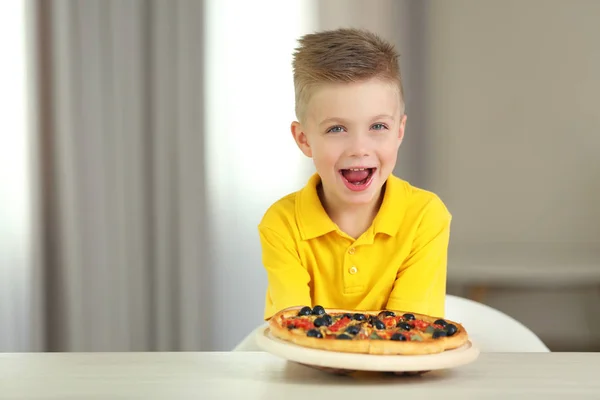 Söt pojke med varm pizza hemma — Stockfoto