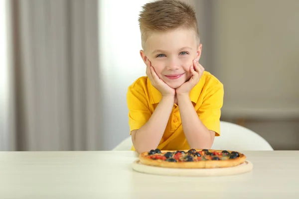 Милый мальчик с горячей пиццей дома — стоковое фото