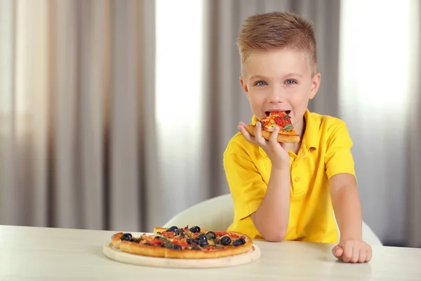 Draguta baiat mananca pizza la domiciliu — Fotografie, imagine de stoc