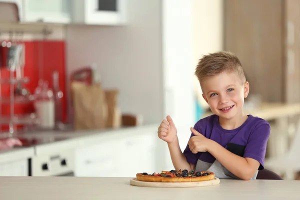 Söt pojke med varm pizza hemma — Stockfoto