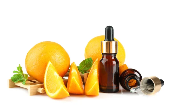 Naranjas, menta y botellas con aceite esencial sobre fondo blanco —  Fotos de Stock
