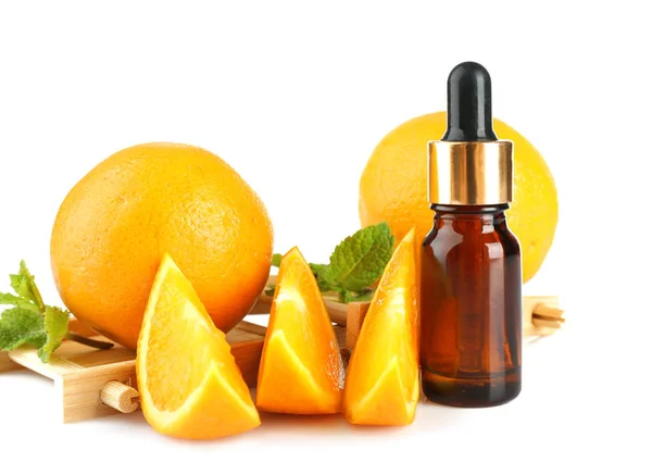 Oranges, mint and bottle with essential oil on white background, closeup — Stock Photo, Image