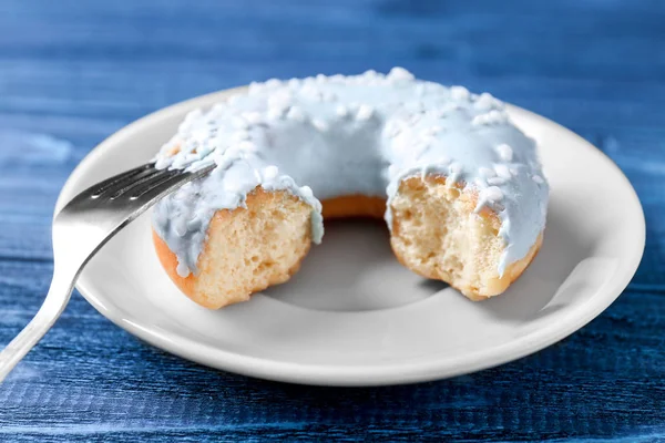 Bitten donut with fork on table — Stock Photo, Image