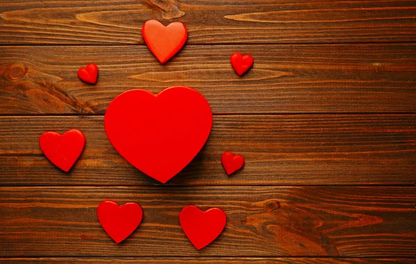 Heart shaped gift box with small hearts on wooden table — Stock Photo, Image