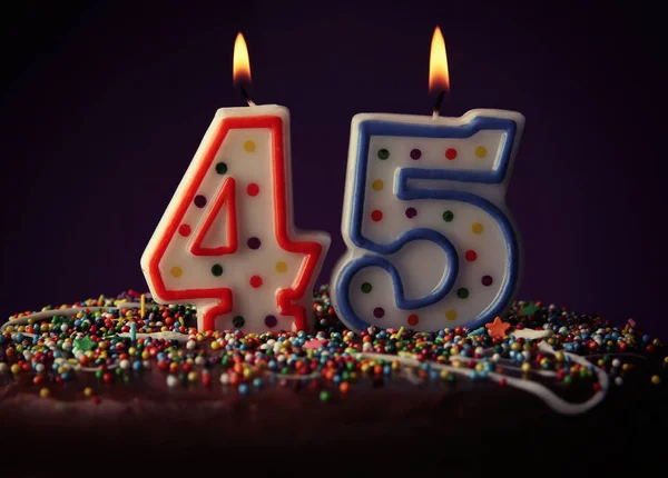 Gâteau d'anniversaire avec des bougies allumées sur fond sombre — Photo