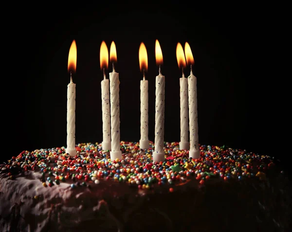 День рождения торт с красочными свечами на темном фоне — стоковое фото