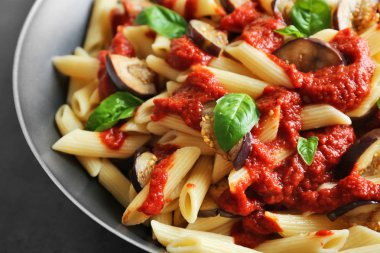 Lezzetli makarna, ketçap, patlıcan dilimleri ve fesleğen ile pan, görünümü kapatın