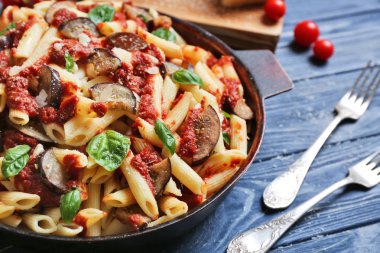 Lezzetli makarna ve ahşap masa üzerinde çatal ile Pan