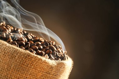 Koyu arka plan üzerine kavrulmuş kahve çekirdekleri ile sack, görünümü kapatın