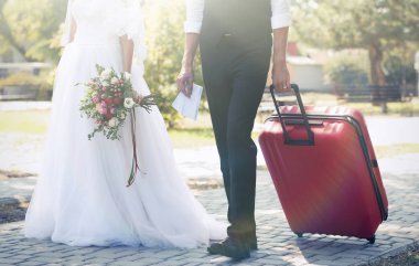 Gelin ve damat ile büyük bavul açık havada yürüyüş
