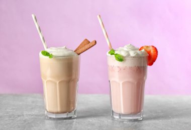 Pembe bir arka plan üzerinde lezzetli milkshake bardak
