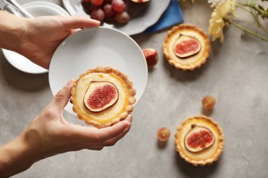 İncirli kek, üstten görünüm tutan el