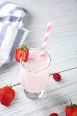Lezzetli milkshake ve Beyaz ahşap zemin üzerinde taze çilek cam
