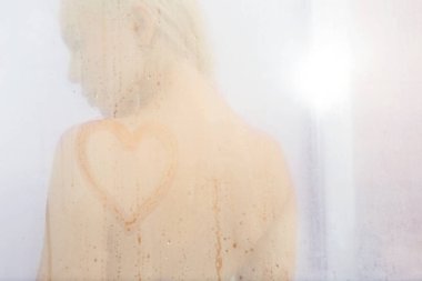 Güzel genç kadın duş kapı cam ağlayan üzerinde çizim