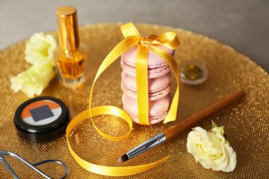 Şerit macaroons ve güzellik aksesuarlar altın yüzeyi ile bağlı