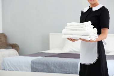 Odaya temiz havlu yığını tutan oda hizmetçisi