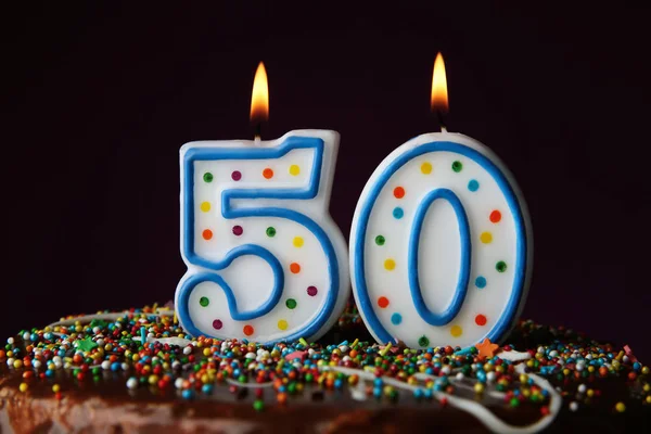 Torta di compleanno con candele accese su sfondo scuro — Foto Stock